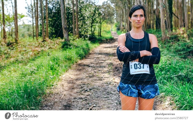 Leichtathletin posiert mit Startnummer Lifestyle schön Sport Mensch Frau Erwachsene Natur Baum Wald Wege & Pfade authentisch selbstbewußt Stolz Konkurrenz