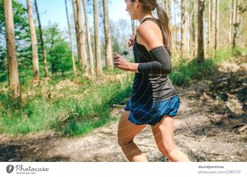 Junge Frau auf Spurensuche Lifestyle Abenteuer Sport Mensch Erwachsene Natur Baum Wald Wege & Pfade Turnschuh Fitness authentisch Geschwindigkeit anstrengen