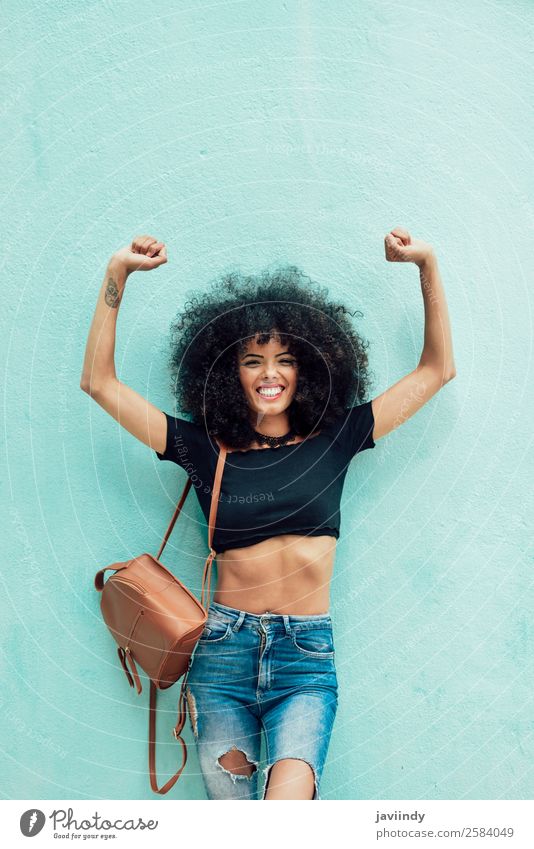 Lustige schwarze Frau mit Afrohaar, die die Arme im Freien hebt. Lifestyle Stil Freude Glück schön Haare & Frisuren Gesicht Mensch feminin Junge Frau