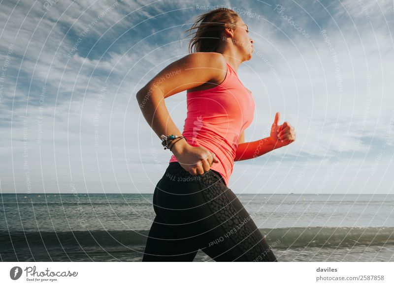 Frau in Sportkleidung läuft an der Meeresküste Lifestyle sportlich Wellness Leben Strand Fitness Sport-Training Sportler Joggen Mensch feminin Junge Frau