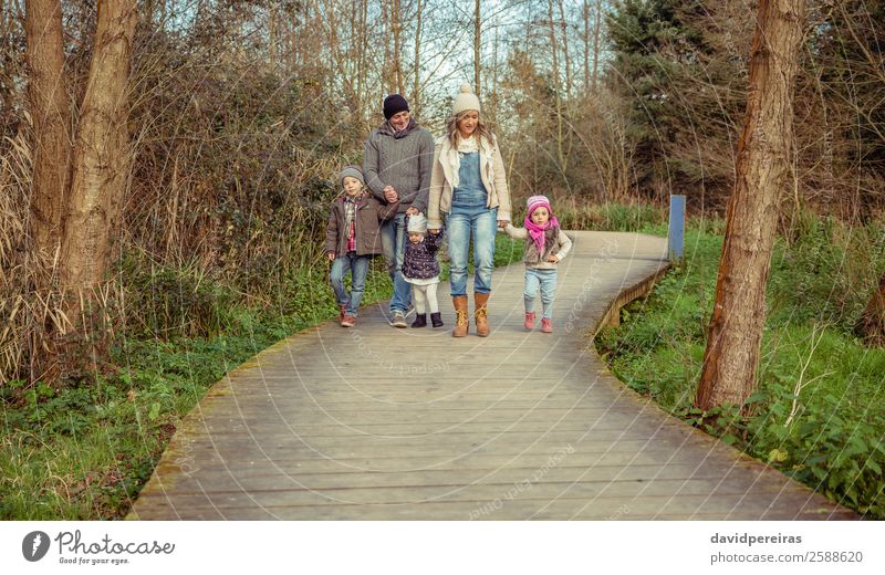 Familie geht gemeinsam über einen Holzweg in den Wald Lifestyle Glück schön Freizeit & Hobby Winter Kind Mensch Baby Junge Frau Erwachsene Mann Eltern Mutter