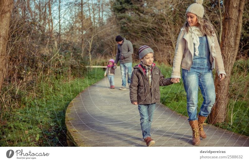 Glückliche Familie, die gemeinsam im Wald Hand in Hand geht. Lifestyle schön Winter Kind sprechen Mensch Junge Frau Erwachsene Mann Eltern Mutter Vater