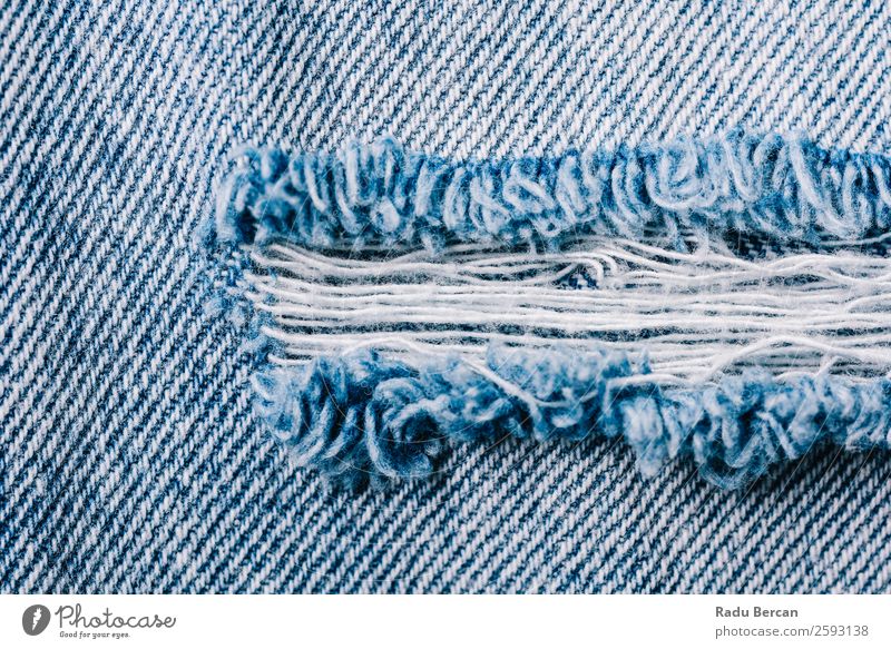 Denim Textur von zerrissenen Jeans Jeanshose gerissen Konsistenz Jeansstoff Hintergrundbild Stoff blau Muster Design lässig Textil Material alt Nahaufnahme Mode