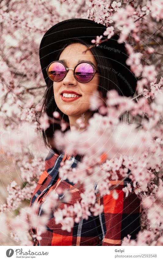 Hübsches brünettes Mädchen Stil Glück schön Gesicht Garten Mensch Frau Erwachsene Natur Baum Blume Blüte Park Mode Sonnenbrille Hut Lächeln Fröhlichkeit frisch