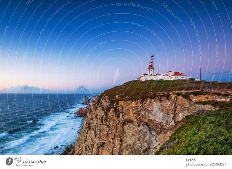 Felsige Steilküste mit Leuchtturm bei fast wolkenloser Abendstimmung Haus Licht Sicherheit Küste Außenaufnahme Farbfoto weiß rot mehrfarbig Portugal