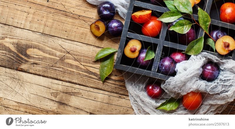 Frische Pflaumen mit Blättern Frucht Ernährung Vegetarische Ernährung Diät Schalen & Schüsseln Sommer Tisch Herbst Blatt Holz frisch saftig braun purpur roh