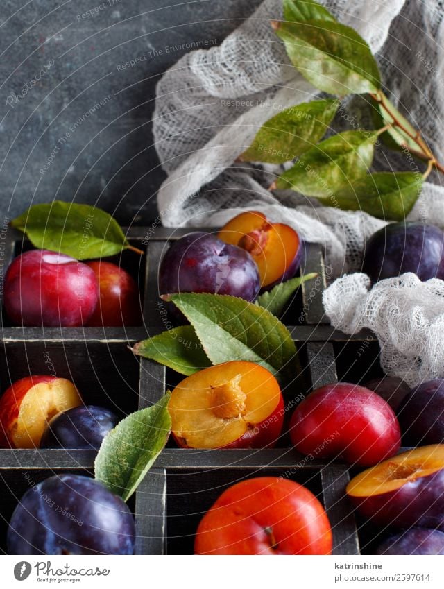 Frische Pflaumen mit Blättern Frucht Ernährung Vegetarische Ernährung Diät Sommer Tisch Herbst Blatt Holz frisch saftig braun grau purpur roh reif Ackerbau süß