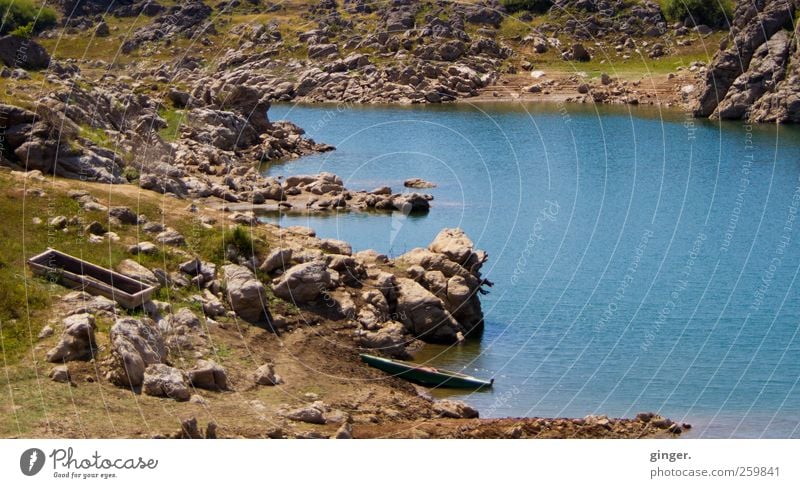 Tiefe Wasser schreien still Umwelt Natur Landschaft Erde Sommer Schönes Wetter Dürre Gras Küste Seeufer trocken Geröll Wasserfahrzeug Kahn Felsen türkis grün