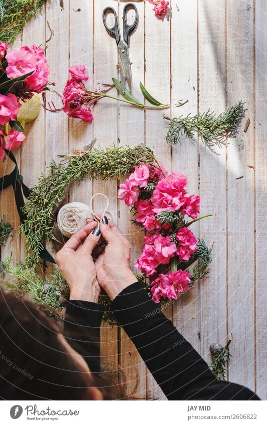 Florist bei der Arbeit Erstellung eines Holzkranzes mit rosa Blumen Dekoration & Verzierung Erntedankfest Weihnachten & Advent Silvester u. Neujahr