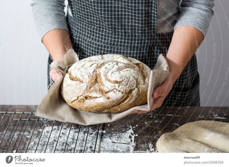 Frau, die zu Hause handgemachtes Brot zeigt. machen knien Hand Küche Schürze Mehl Hefe selbstgemacht backen Teigwaren Mensch Vorbereitung rühren Zutaten roh