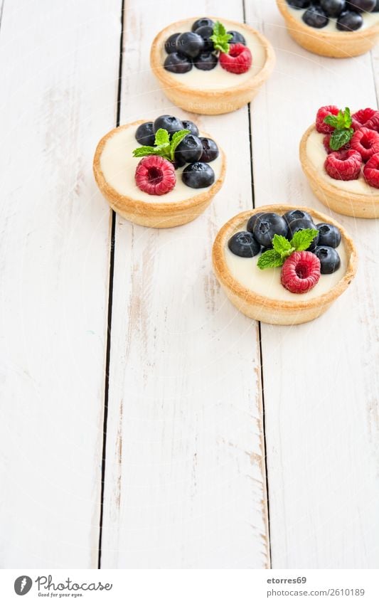 Köstliche Törtchen Blaubeeren Himbeeren Frucht Dessert Lebensmittel Foodfotografie Gesunde Ernährung Speise lecker Sahne Vanillepudding Snack verglast Backwaren