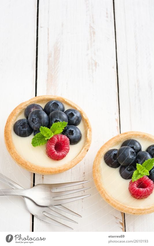 Köstliche Törtchen mit Himbeeren und Heidelbeeren Blaubeeren Frucht Dessert Lebensmittel Foodfotografie Gesunde Ernährung Speise lecker Sahne Vanillepudding