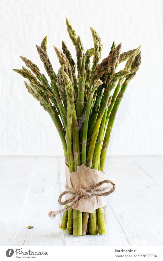 Frische rohe Spargelstangen auf einem weißen Tisch Gemüse Ernährung Abendessen Vegetarische Ernährung Diät frisch grün rustikal saisonbedingt Speer