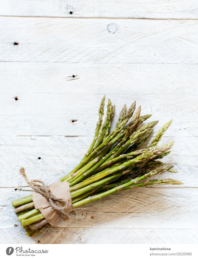 Frische rohe Spargelstangen auf einem weißen Tisch Gemüse Ernährung Abendessen Vegetarische Ernährung Diät frisch oben grün schwarz rustikal saisonbedingt Speer