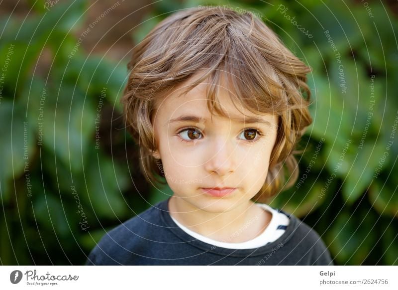 Entzückendes kleines Kind auf dem Feld mit Blick in die Kamera Freude Glück schön Gesicht Spielen Baby Junge Kindheit Natur Pflanze Baum Park Lächeln lachen