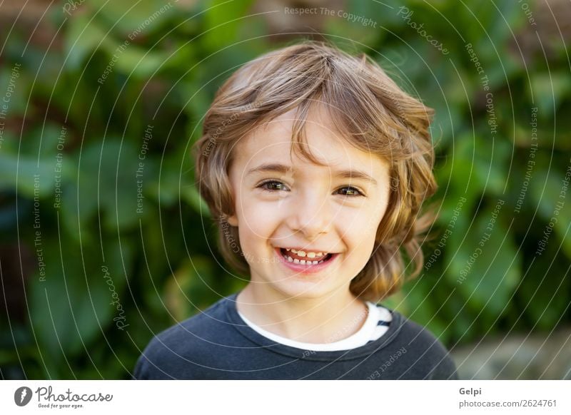 Entzückendes kleines Kind auf dem Feld mit Blick in die Kamera Freude Glück schön Gesicht Spielen Baby Junge Kindheit Natur Pflanze Baum Park Lächeln lachen