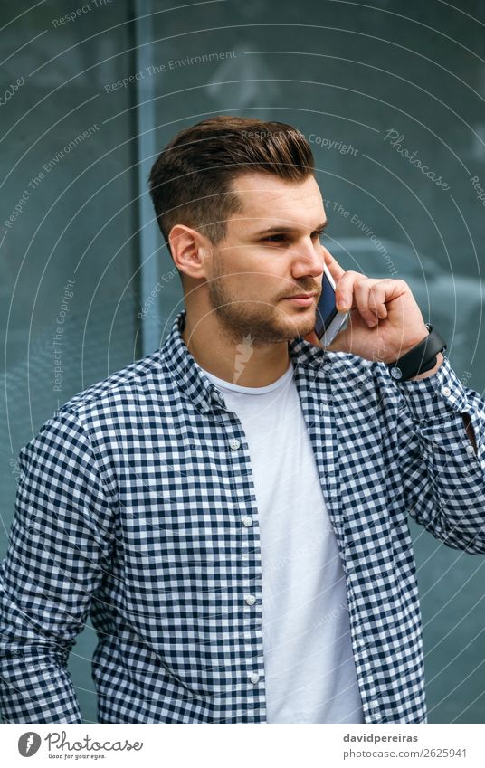 Junger Mann spricht auf dem Handy Lifestyle Haare & Frisuren Freizeit & Hobby sprechen Telefon PDA Technik & Technologie Mensch Erwachsene T-Shirt Vollbart