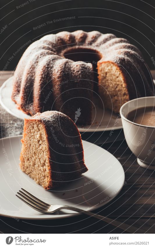 Stück Bundkuchen mit Kaffee Joghurt Dessert Frühstück Tee Teller Gabel Tisch Holz dunkel frisch saftig braun Tradition Kuchen backen Lebensmittel gebastelt süß