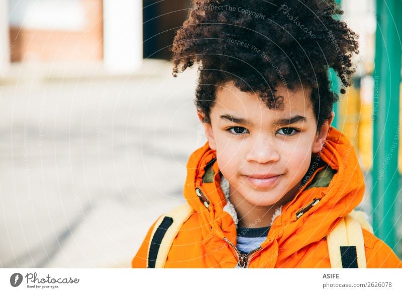 Kleiner Schuljunge am Eingang der Schule Glück Winter Kind Junge Herbst Mantel Lächeln klein gelb schwarz Schulkind Rucksack Schüler gutaussehend Afrikanisch