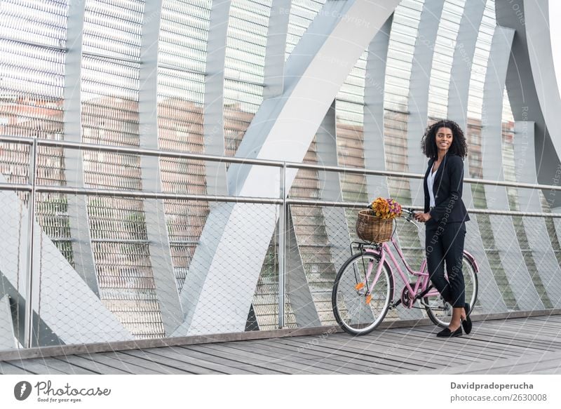 Geschäftsschwarze Frau mit Vintage-Fahrrad in einer Brücke Business Fahrradfahren altehrwürdig Person gemischter Abstammung Großstadt Jugendliche Mensch Anzug