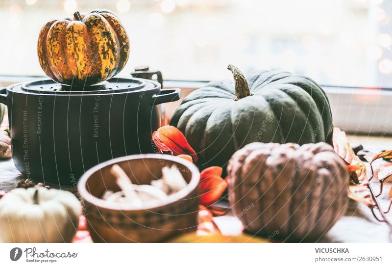 Kochtopf und Kürbisse auf dem Küchentisch am Fenster Lebensmittel Gemüse Ernährung Topf Design Gesunde Ernährung Winter Häusliches Leben Herbst Hintergrundbild