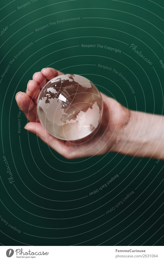 Hand with transparent globe in front of green background Natur Horizont Globus Erde durchsichtig festhalten dunkelgrün Nordamerika Südamerika Amerika Pazifik