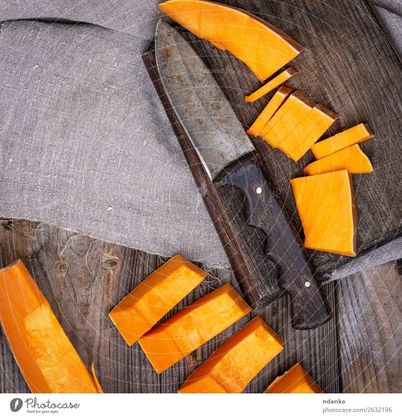 geschnittener Kürbis auf einem braunen Schneidebrett Gemüse Ernährung Diät Natur Herbst Holz frisch lecker gelb Scheibe Hintergrund aufgeschnitten Top roh