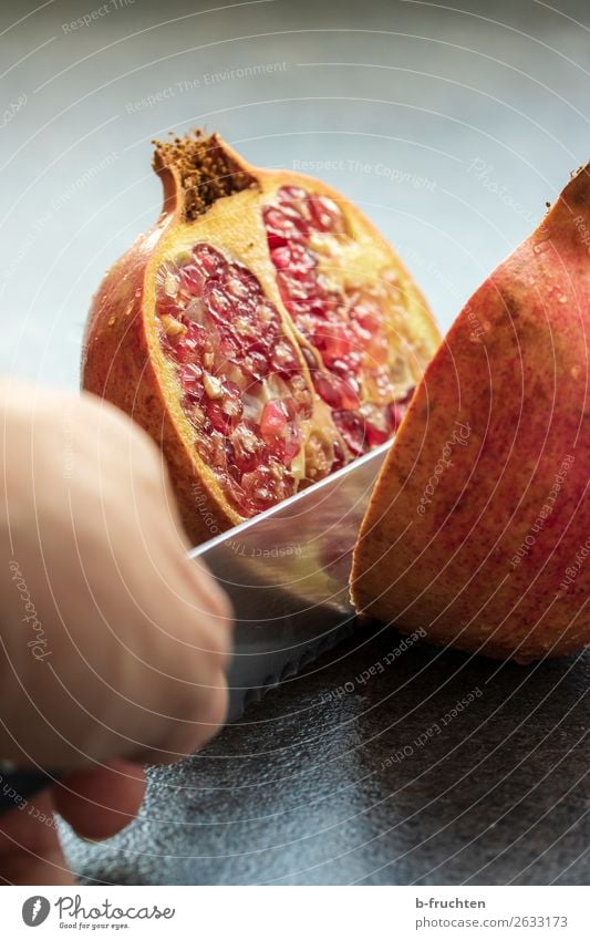 Granatapfel schneiden Frucht Bioprodukte Vegetarische Ernährung Gesunde Ernährung Hand Finger frisch Gesundheit rot Kerne Essen zubereiten Hälfte Messer