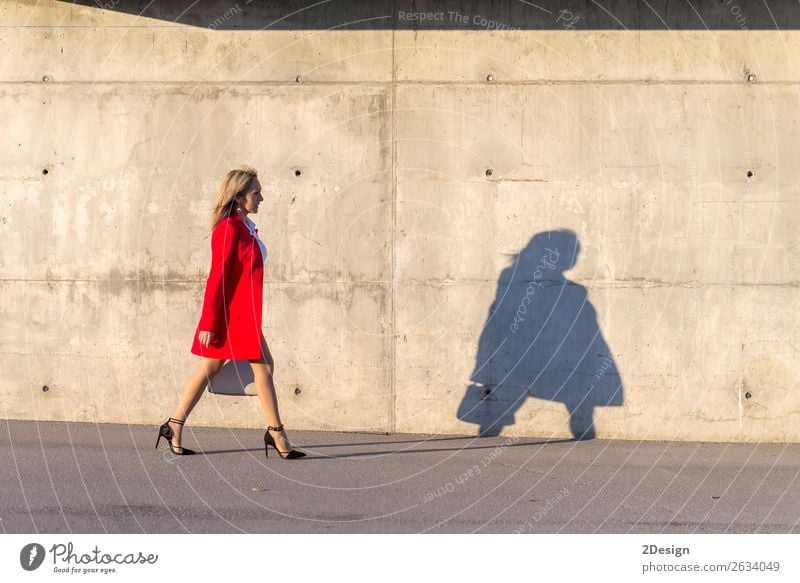 Blonde Frau in roter Jacke, die auf der Straße geht. Lifestyle schön Business feminin Erwachsene Hemd Rock Schuhe Damenschuhe blond schwarz weiß Geschäftsfrau