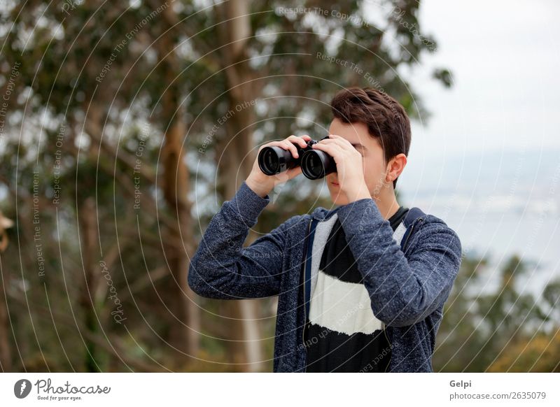 Teenager-Typ, der mit einem Fernglas aussieht. Lifestyle Freude Glück Freizeit & Hobby Sommer Kind Mensch Junge Mann Erwachsene Kindheit Jugendliche Hand Baum