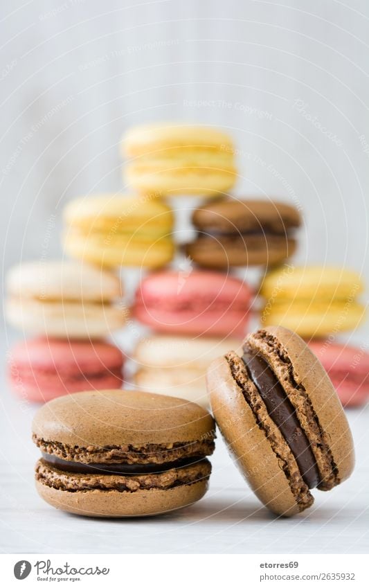 Bunte Makronen auf weißem Holztisch Macaron Erdbeeren Zitrone Dessert Kaffee gelb Schokolade Konfekt Himbeeren Tradition Süßwaren Bonbon Plätzchen ausstechen