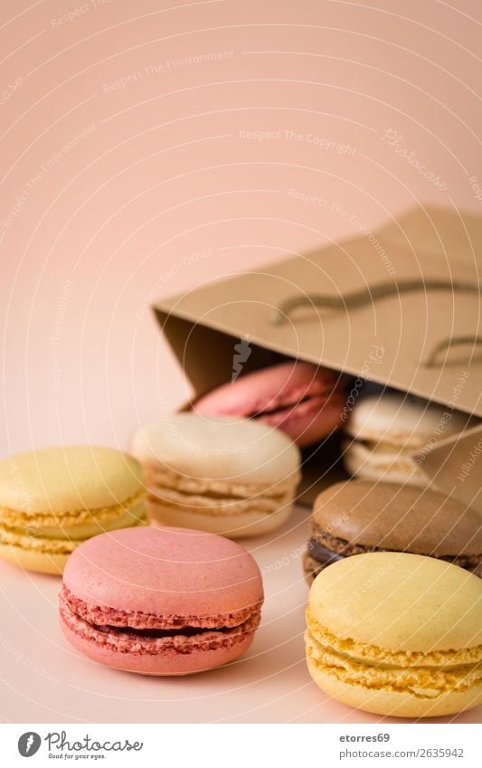 Bunte Makaundrons auf braunem Hintergrund. Macaron Erdbeeren Zitrone Dessert Kaffee gelb Schokolade Konfekt Himbeeren Tradition Süßwaren Bonbon