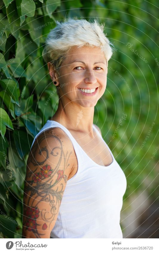 Frau mit geblümten Tattoos auf dem Arm. Lifestyle Stil Glück schön Körper Sommer Erwachsene Arme Punk Natur Pflanze Blume Park Mode Schmuck blond Lächeln