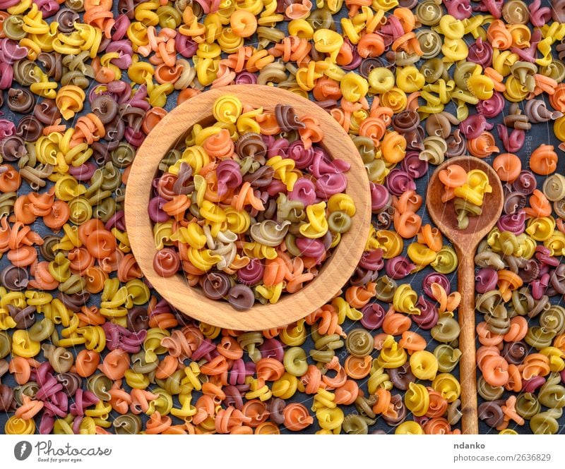 mehrfarbige spiralförmige Rohteigwaren-Fusilli in einer Holzschale Teigwaren Backwaren Ernährung Abendessen Diät Schalen & Schüsseln Löffel Essen frisch braun