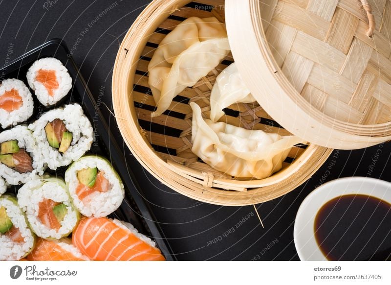 Knödel oder Gyoza auf traditionellem Dampfgarer und Sushi serviert. Gemüse Fisch maki Lebensmittel Gesunde Ernährung Foodfotografie Reis Brötchen Meeresfrüchte