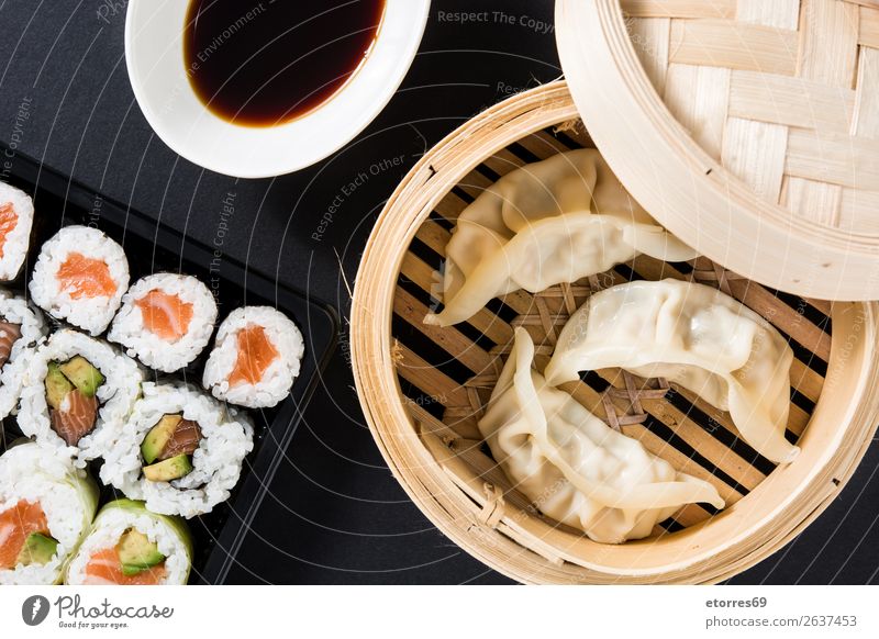 Knödel oder Gyoza auf traditionellem Dampfgarer und Sushi serviert. Gemüse Fisch maki Lebensmittel Gesunde Ernährung Foodfotografie Reis Brötchen Meeresfrüchte