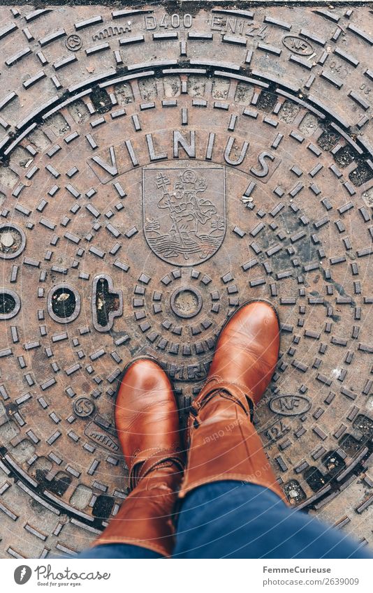 Person with brown boots standing on a manhole cover in Vilnius feminin Junge Frau Jugendliche Erwachsene Fuß 1 Mensch 18-30 Jahre 30-45 Jahre