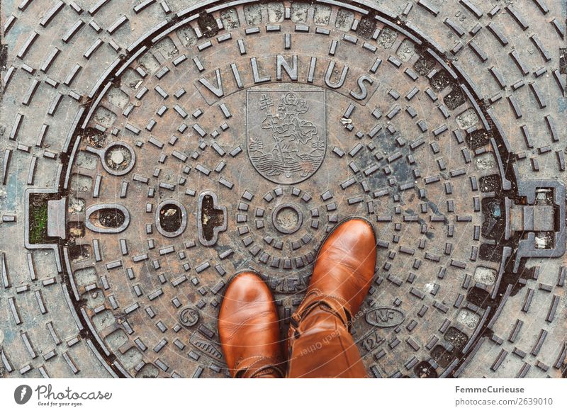 Person with brown boots standing on a manhole cover in Vilnius Lifestyle feminin Junge Frau Jugendliche Erwachsene 1 Mensch Ferien & Urlaub & Reisen Gully