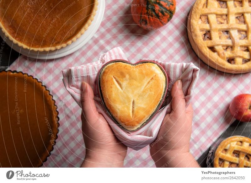 Frauenhände halten eine herzförmige Pastete über einem Tisch. Dessert Küche Erwachsene Herbst außergewöhnlich viele Tradition Erntedankfest obere Ansicht