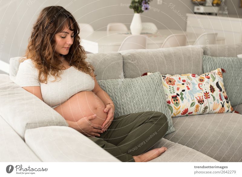 Schwangere Frau, die ihren Bauch berührt. Lifestyle Glück schön Leben Freizeit & Hobby Sofa Mensch Baby Erwachsene Eltern Mutter Familie & Verwandtschaft