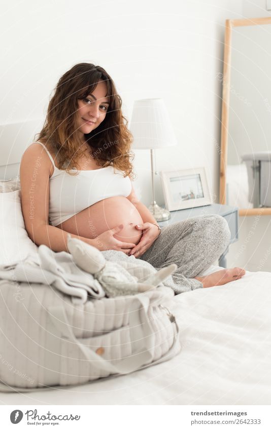 Schwangere Frau, die ihren Bauch berührt. Lifestyle Glück schön Leben Freizeit & Hobby Sofa Mensch Baby Erwachsene Eltern Mutter Familie & Verwandtschaft