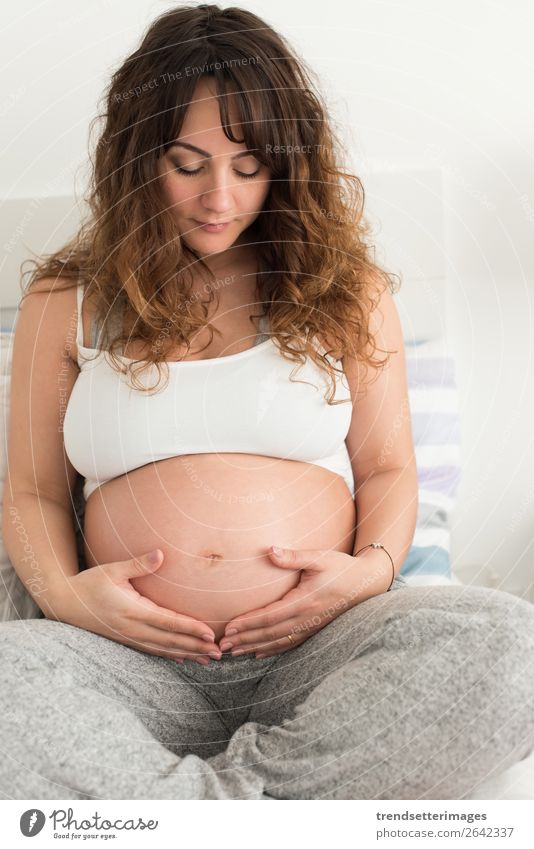 Schwangere Frau, die ihren Bauch berührt. Lifestyle Glück schön Leben Freizeit & Hobby Sofa Mensch Baby Erwachsene Eltern Mutter Familie & Verwandtschaft