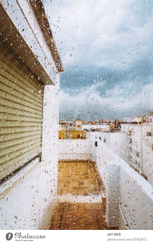 Fenster mit Regentropfen drauf. Stürmischer Himmel. Wolken schlechtes Wetter Unwetter Terrasse Traurigkeit trist grau Farbe heimwärts kalt traurig Außenseite