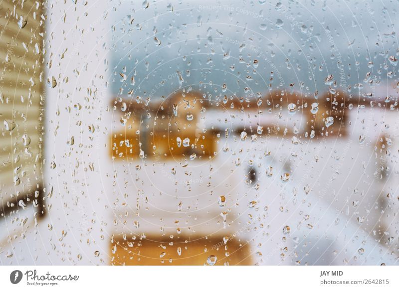 Fenster mit Regentropfen darauf mit Blick auf die Terrasse Himmel Wolken schlechtes Wetter Unwetter Traurigkeit trist grau Farbe heimwärts kalt traurig