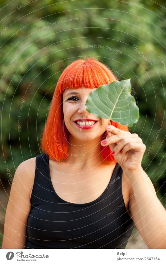 Rothaariges Mädchen mit einem Baumblatt Lifestyle Glück schön Gesicht Schminke Mensch Frau Erwachsene Natur Herbst Blatt Park Wald Mode Lächeln Fröhlichkeit rot