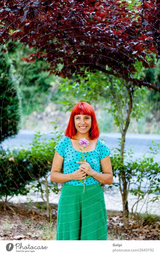 Rothaarige Frau, die eine Blume in einem Park riecht. Lifestyle Glück schön Gesicht Wellness Erholung Duft Sommer Garten Mensch Erwachsene Natur Baum Blüte Mode