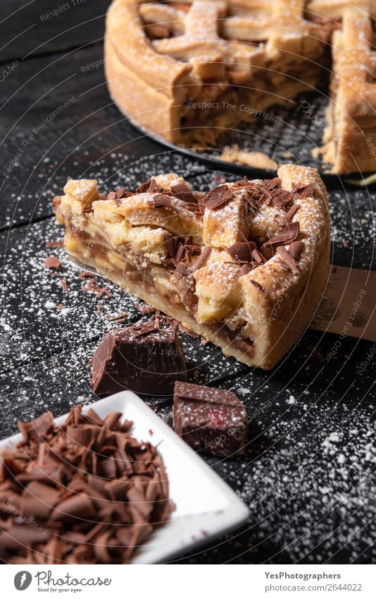 Apfelkuchen im Ganzen und in Scheiben schneiden mit Schokolade. Traditionelle Süßigkeiten Dessert Küche Herbst lecker schwarz Erntedankfest Amerikaner backen