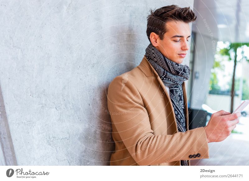 Moderner junger Mann mit Handy auf der Straße. elegant Stil schön Haare & Frisuren Winter Telefon PDA Mensch Erwachsene Jugendliche Herbst Bekleidung Jeanshose