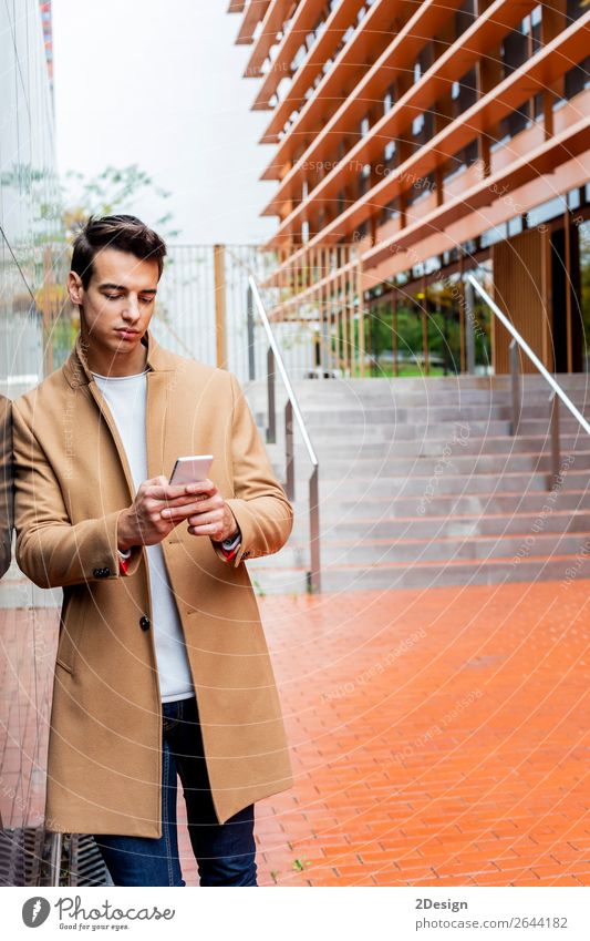 Junger Mann in Winterkleidung auf der Straße beim Telefonieren elegant Stil schön Haare & Frisuren PDA Mensch Erwachsene Jugendliche Herbst Mode Bekleidung