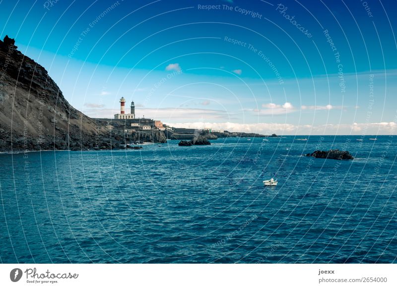 Zwei Leuchttürme direkt am Meer vor Steilküste mit kleinem Boot auf dem blauen Wasser Leuchtturm Küste Landschaft Natur Außenaufnahme Farbfoto Himmel